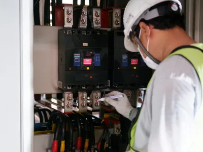 Electrician inspecting an electrical switchboard after a safety switch trips in Brisbane.
